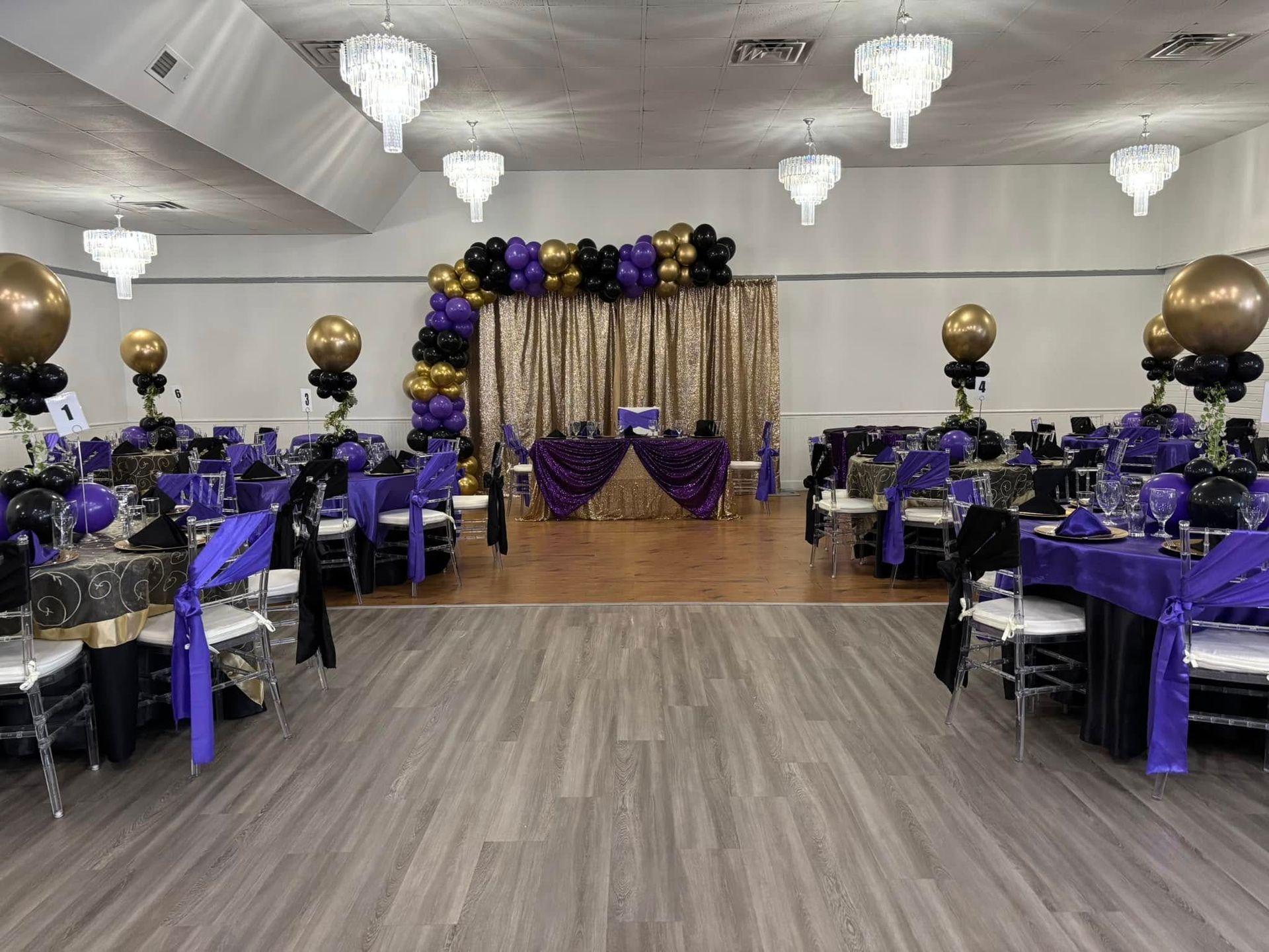 A large room filled with tables and chairs and balloons.