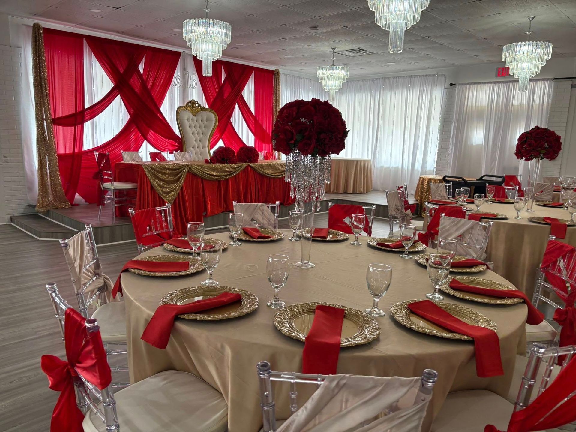 A large room with tables and chairs set up for a wedding reception.