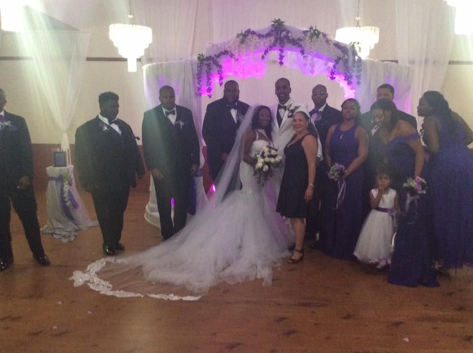 A bride and groom are posing for a picture with their wedding party.