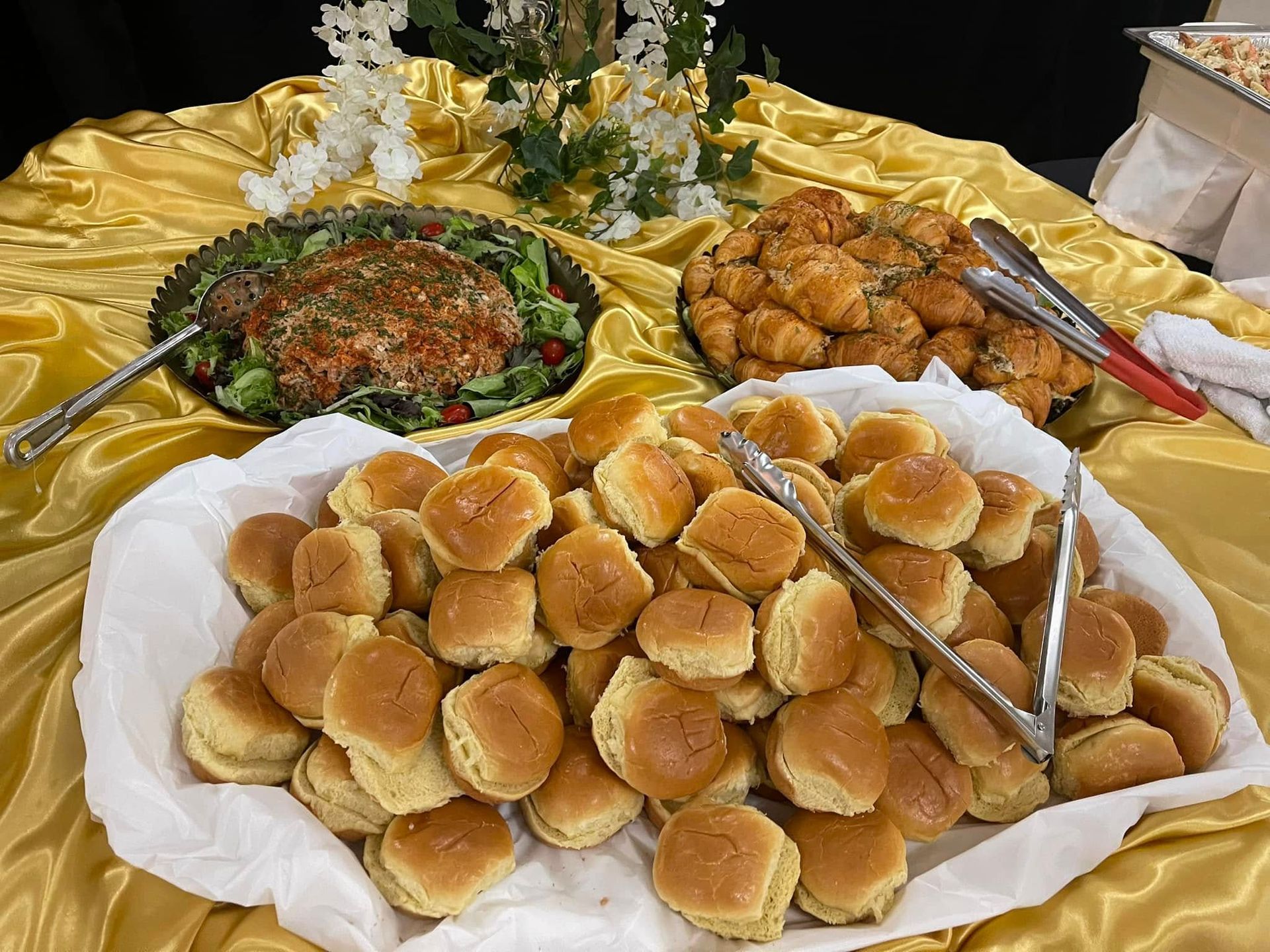 A table topped with a bunch of sandwiches and tongs.