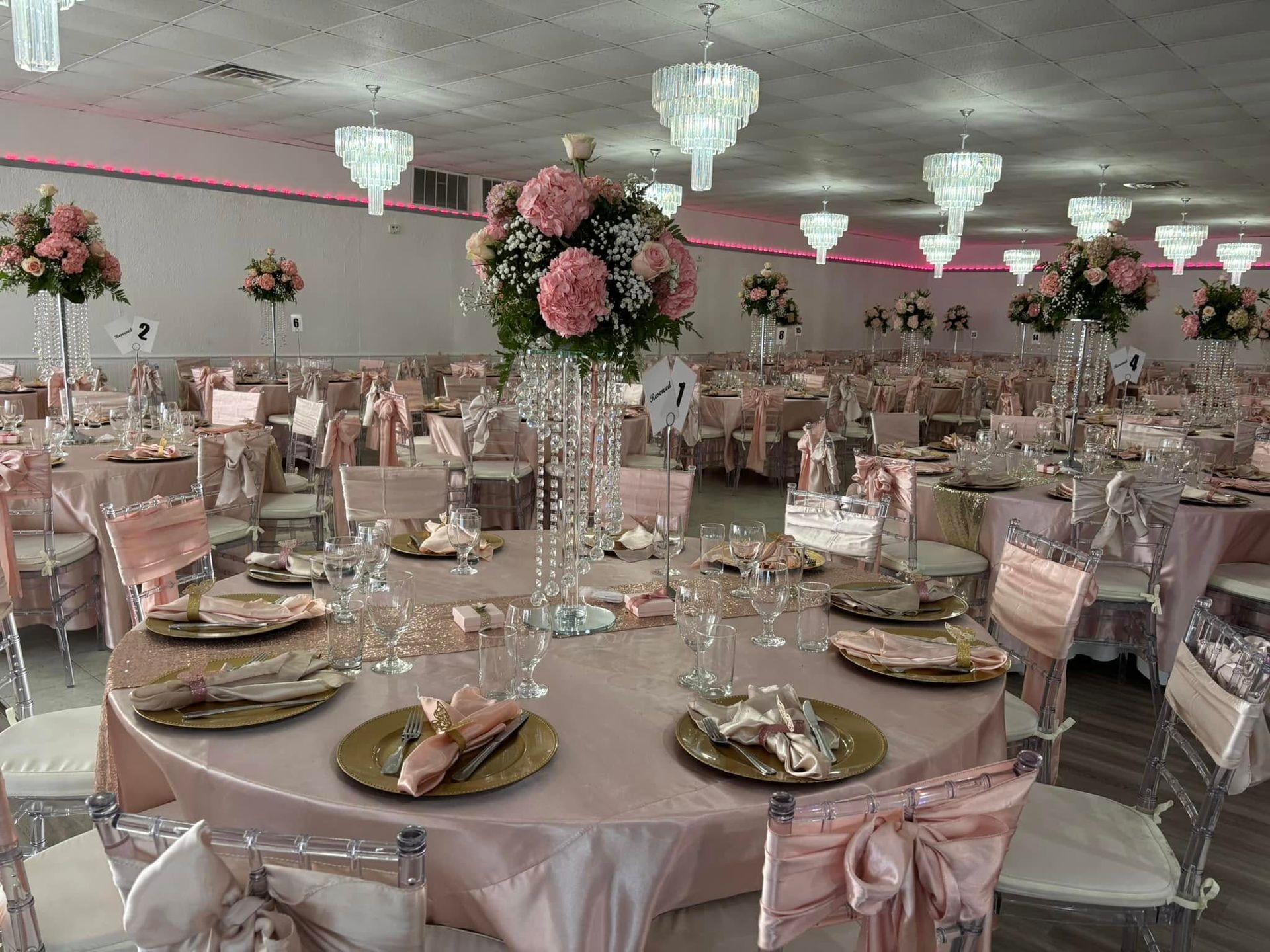 A large room with tables and chairs set up for a wedding reception.