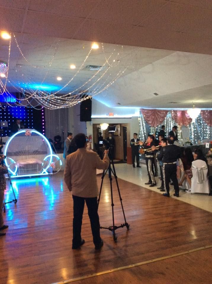 A man is taking a picture of a group of people dancing on a dance floor.