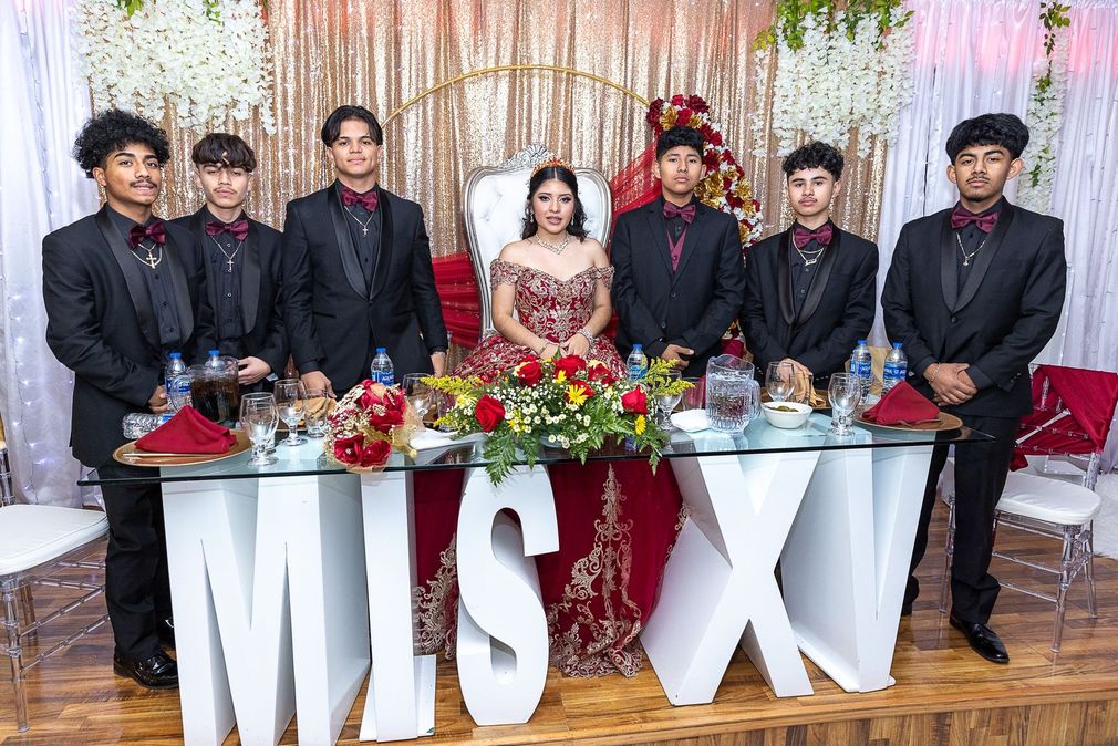 A group of people are posing for a picture at a quinceanera.