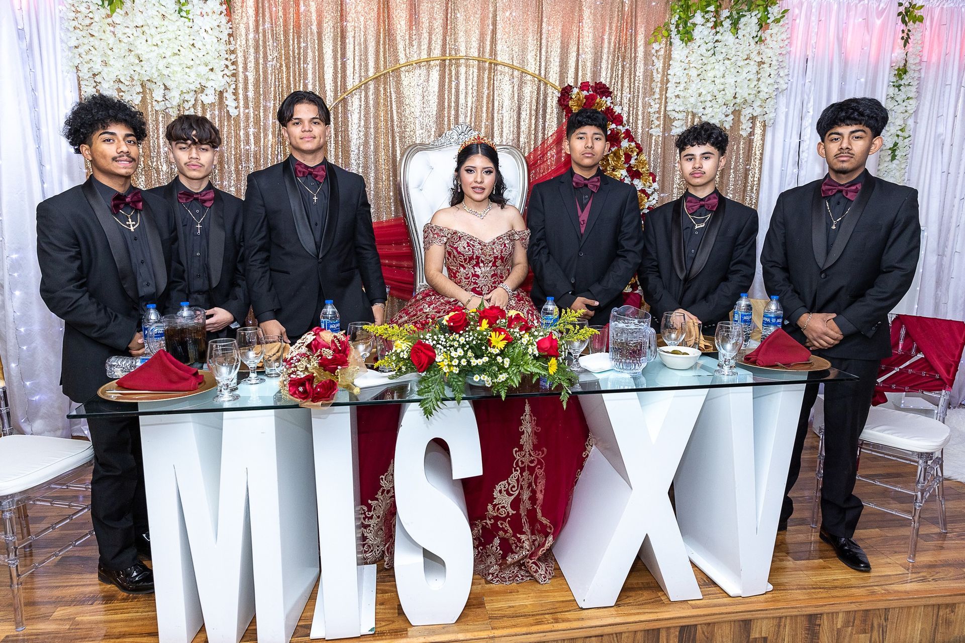 A group of people are posing for a picture at a quinceanera.