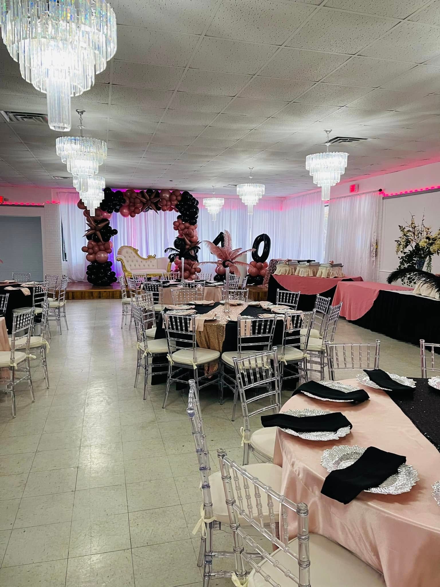 A large room with tables and chairs set up for a wedding reception.