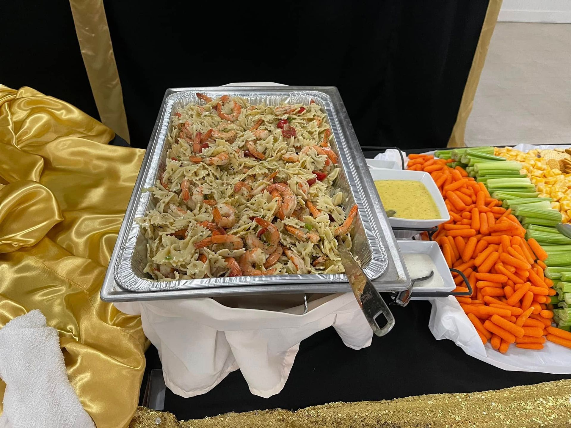 A tray of food is sitting on a table next to carrots and celery.
