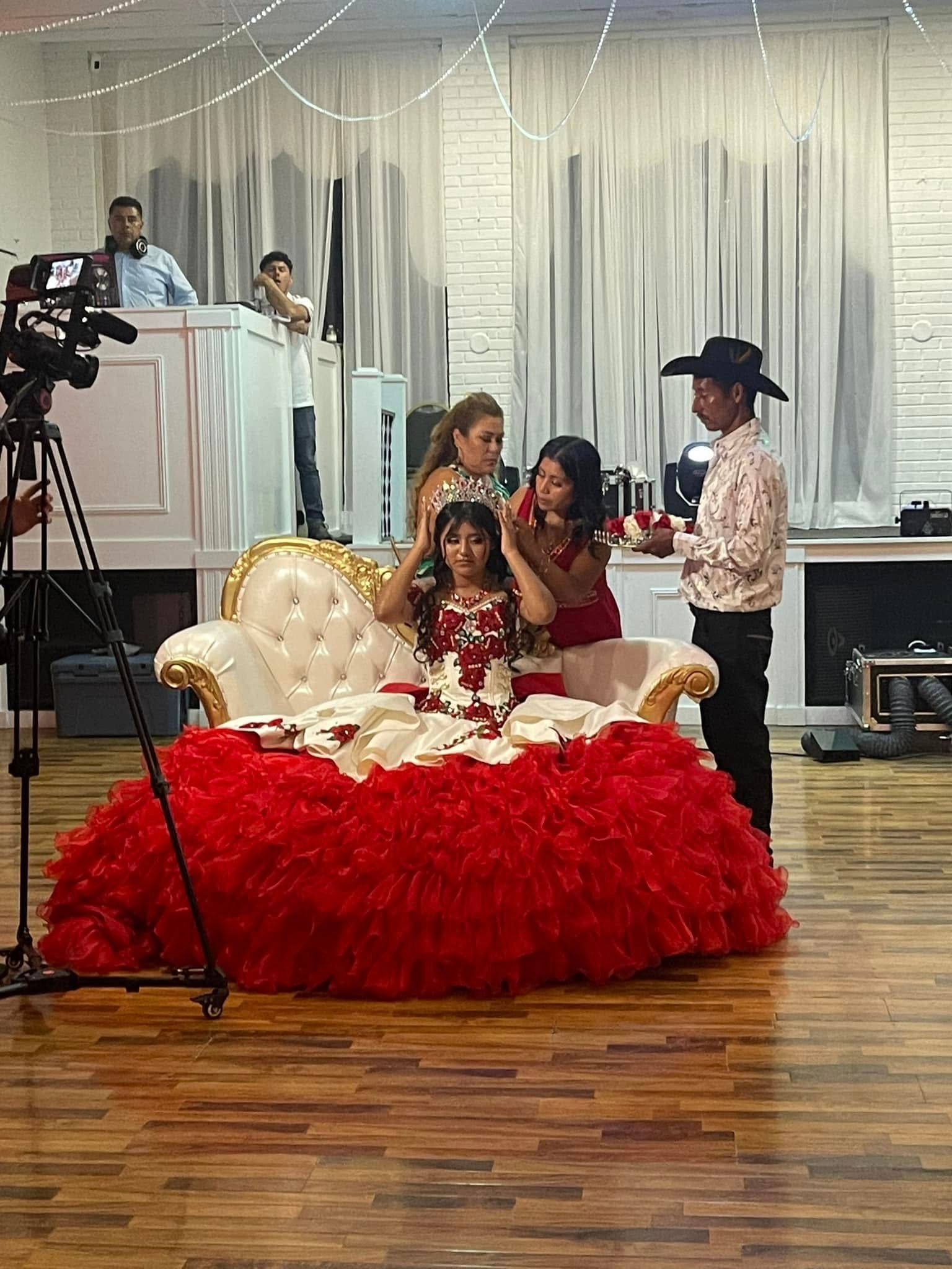 A woman in a red dress is sitting on a chair in a room.