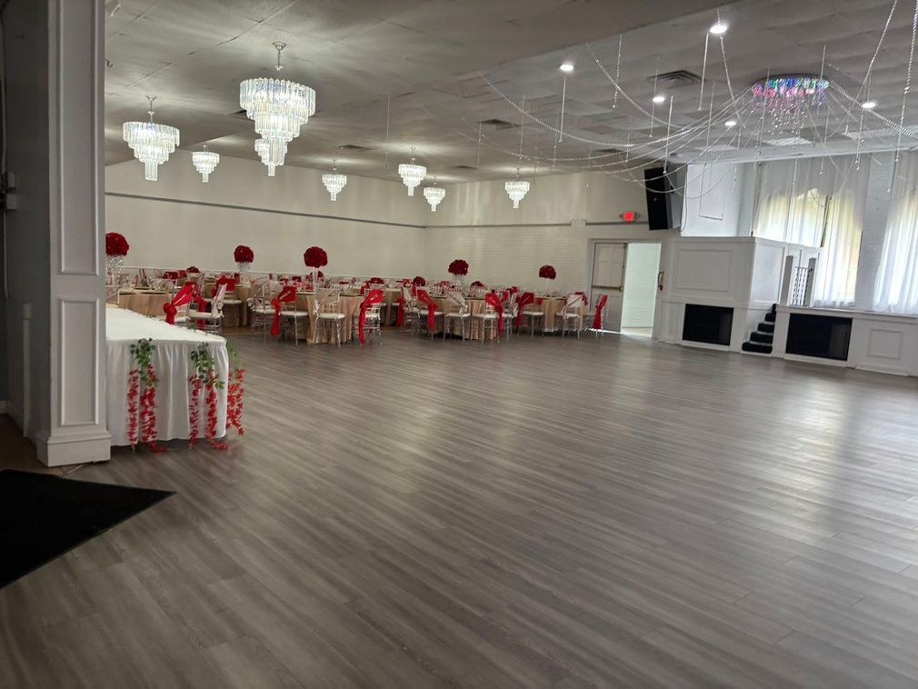 A large room with tables and chairs set up for a wedding reception.
