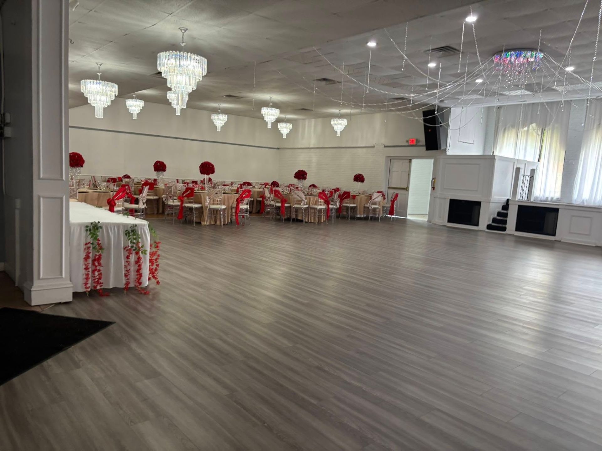 A large room with tables and chairs set up for a wedding reception.