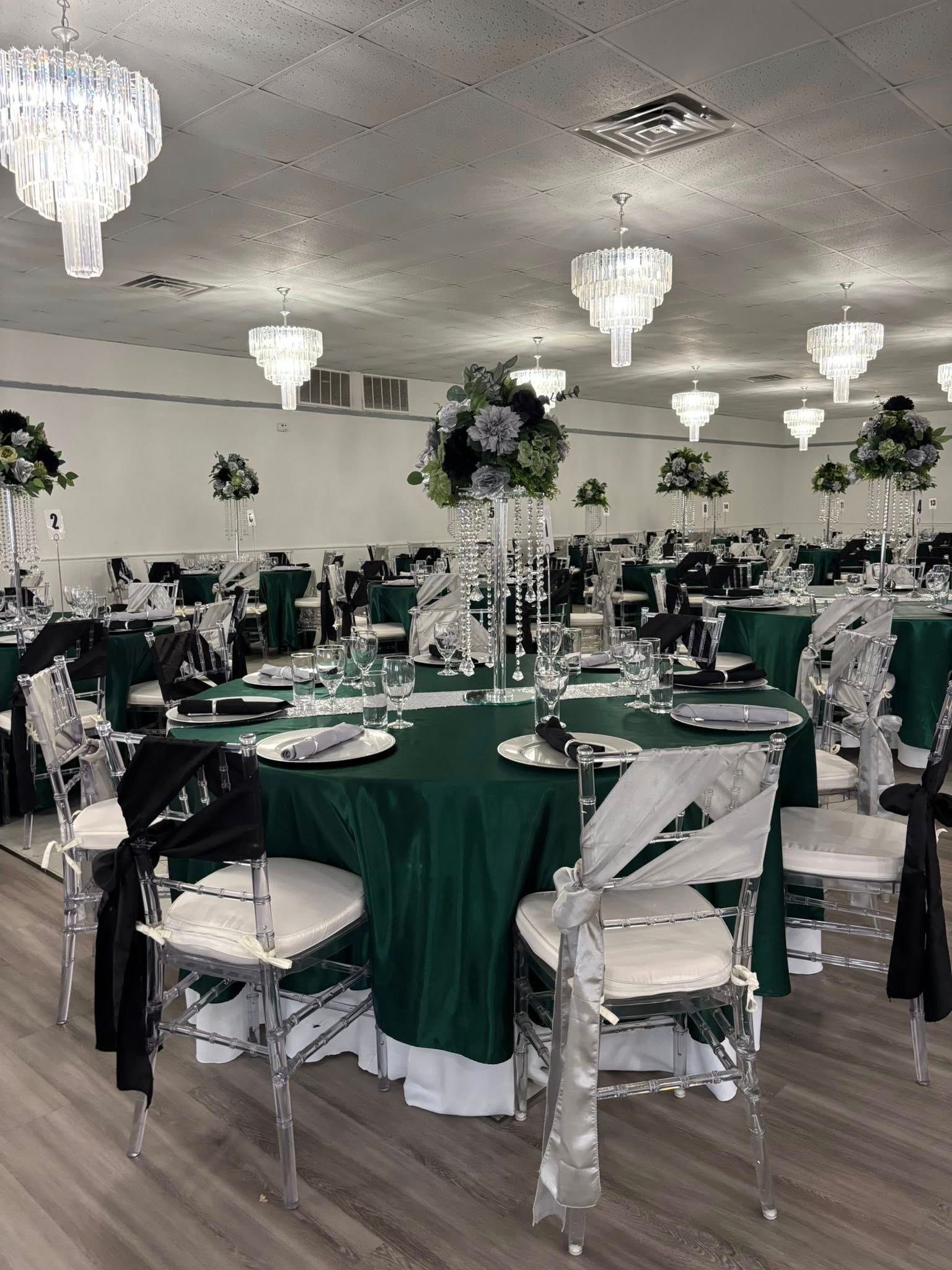 A large room with tables and chairs set up for a wedding reception.