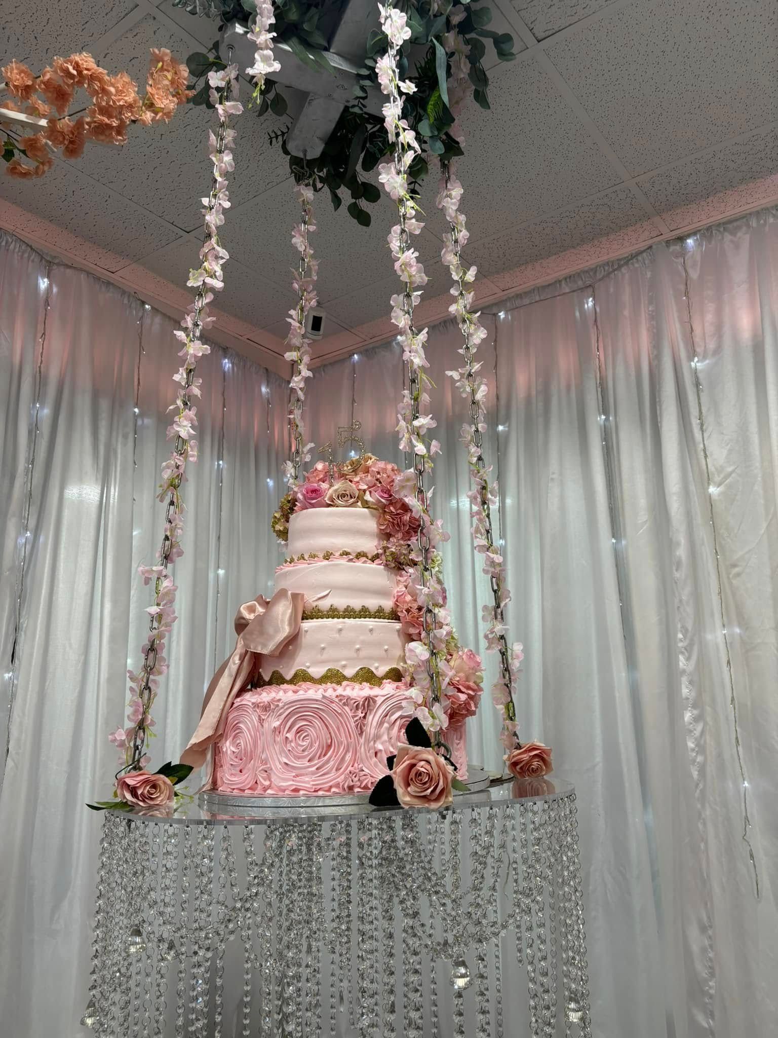 A wedding cake is hanging from the ceiling in a room.