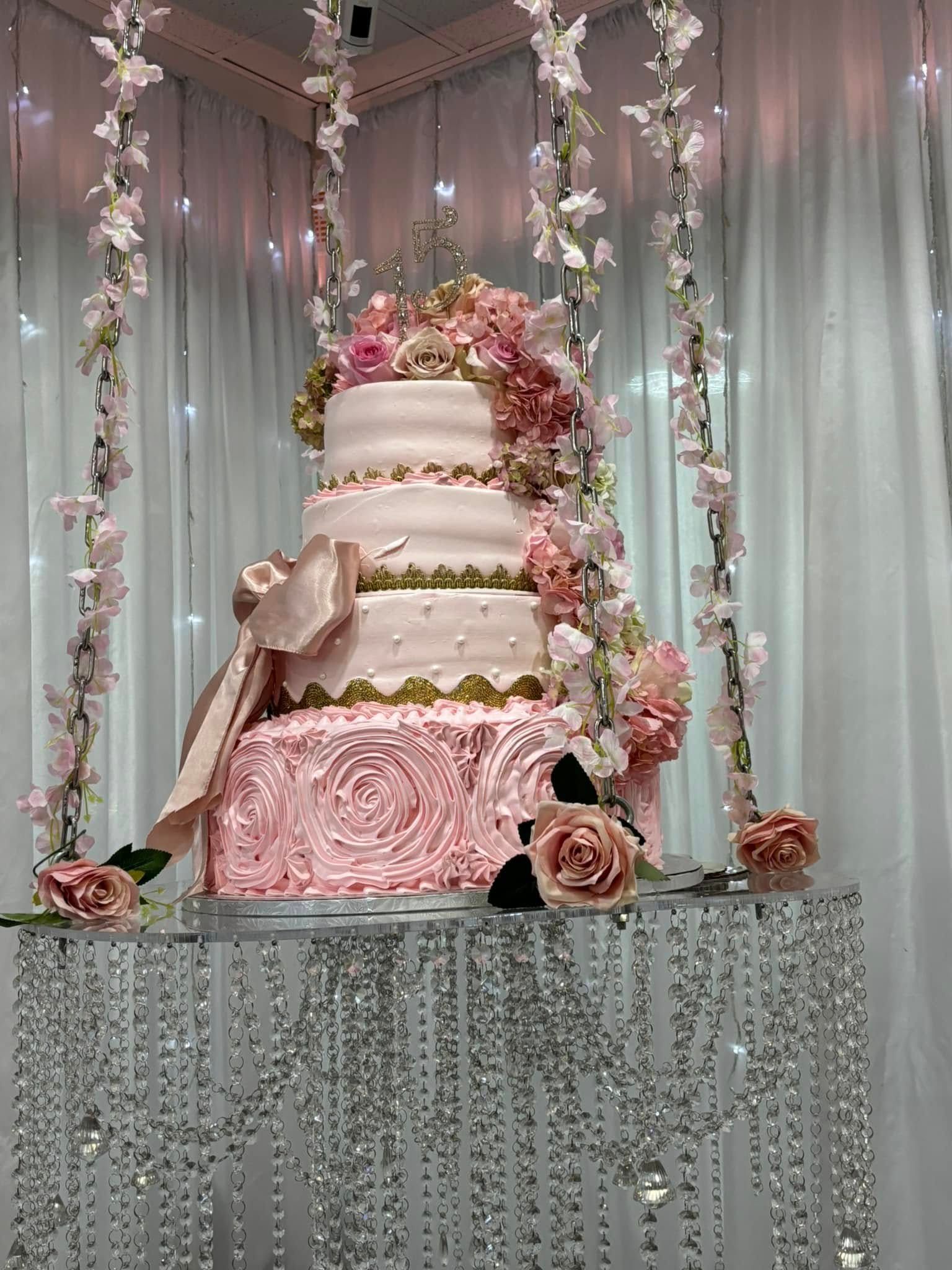 A wedding cake is hanging from the ceiling on a table.
