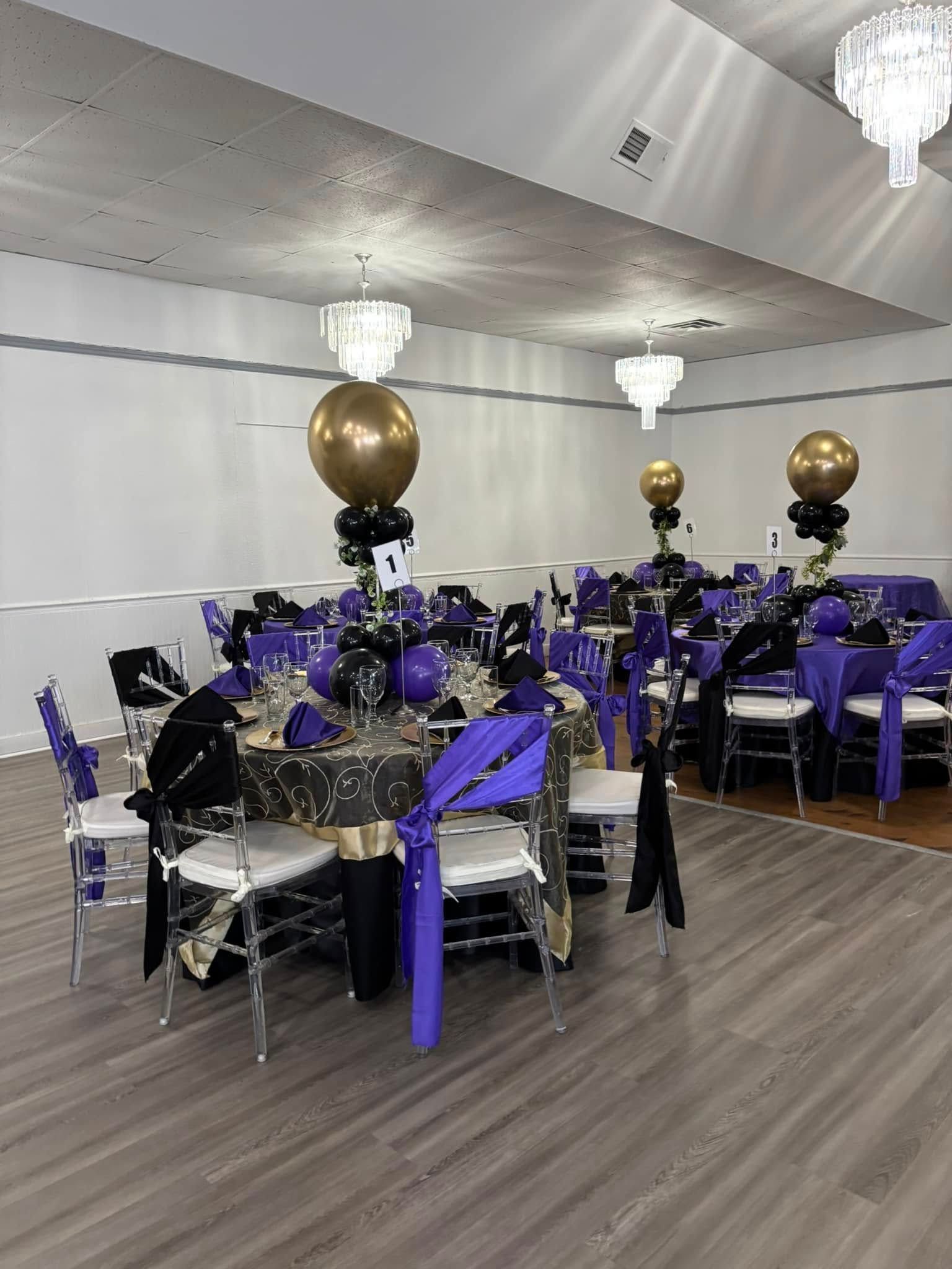 A large room filled with tables and chairs decorated for a party.