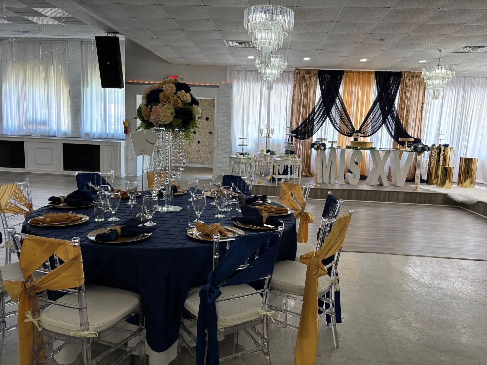 A large room with tables and chairs set up for a wedding reception.