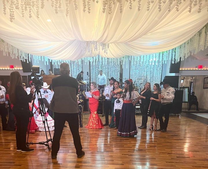 A group of people are dancing in a large room.