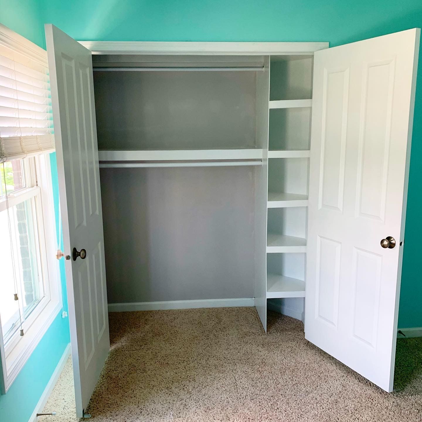 An empty closet with the doors open and shelves.