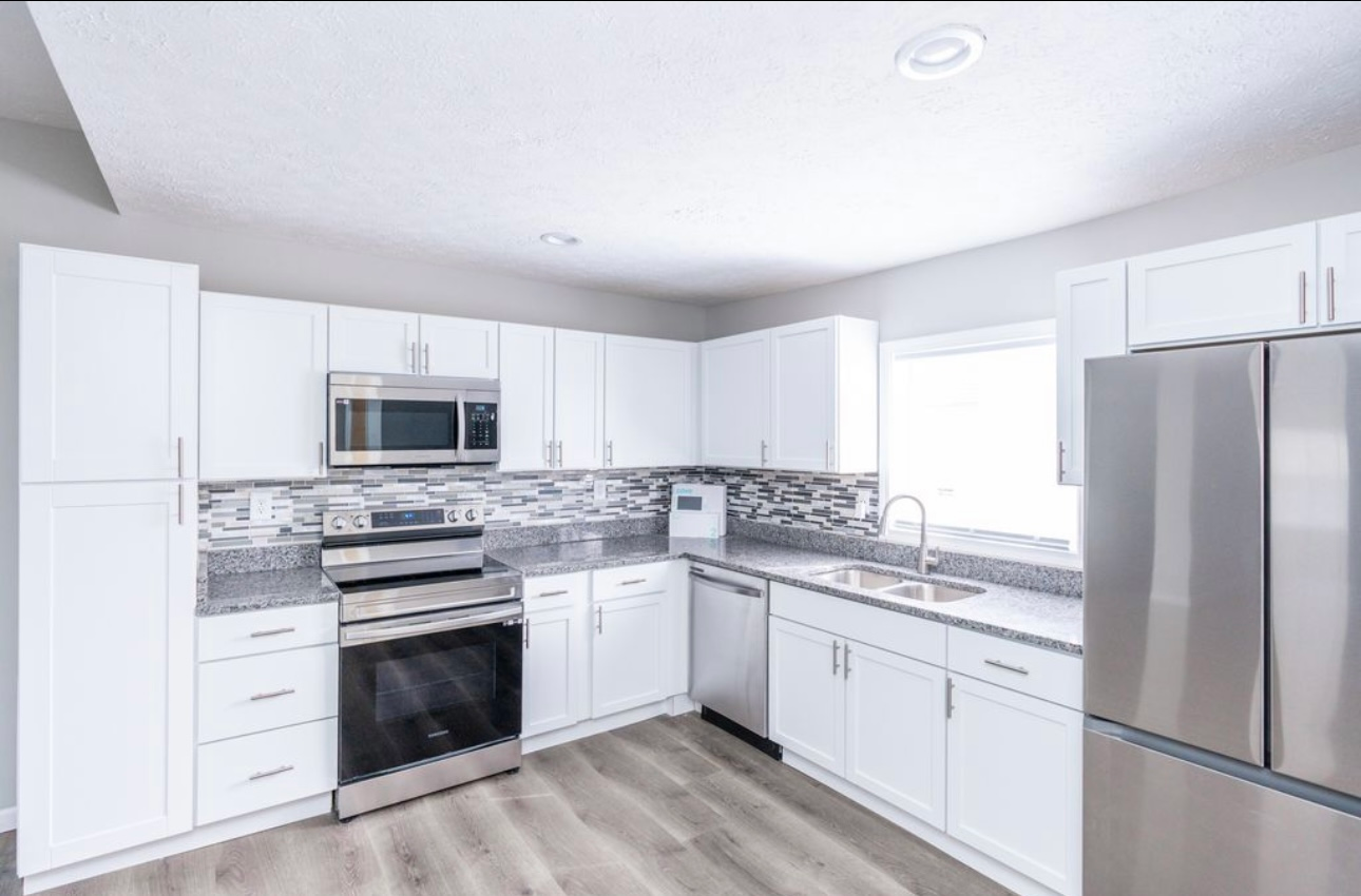 A kitchen with white cabinets and stainless steel appliances.