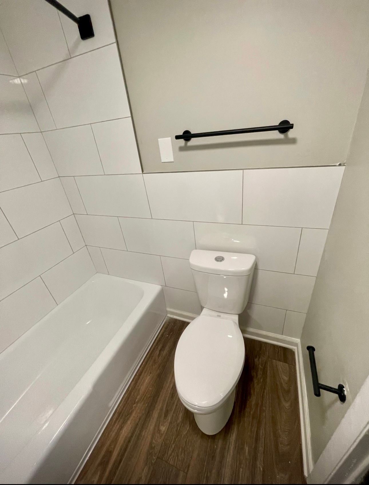 A bathroom with a toilet , bathtub and shower.