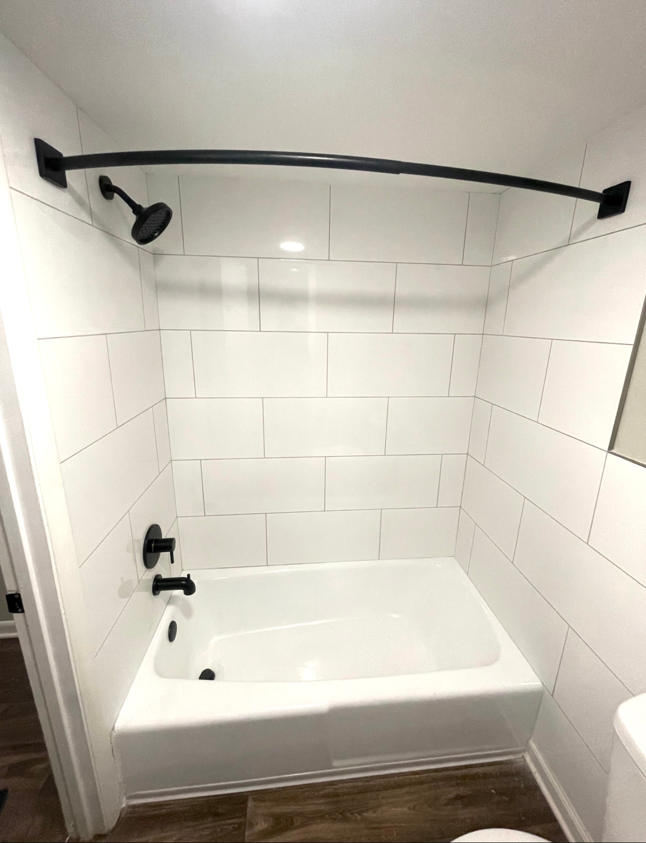 A bathroom with a bathtub , toilet and shower.