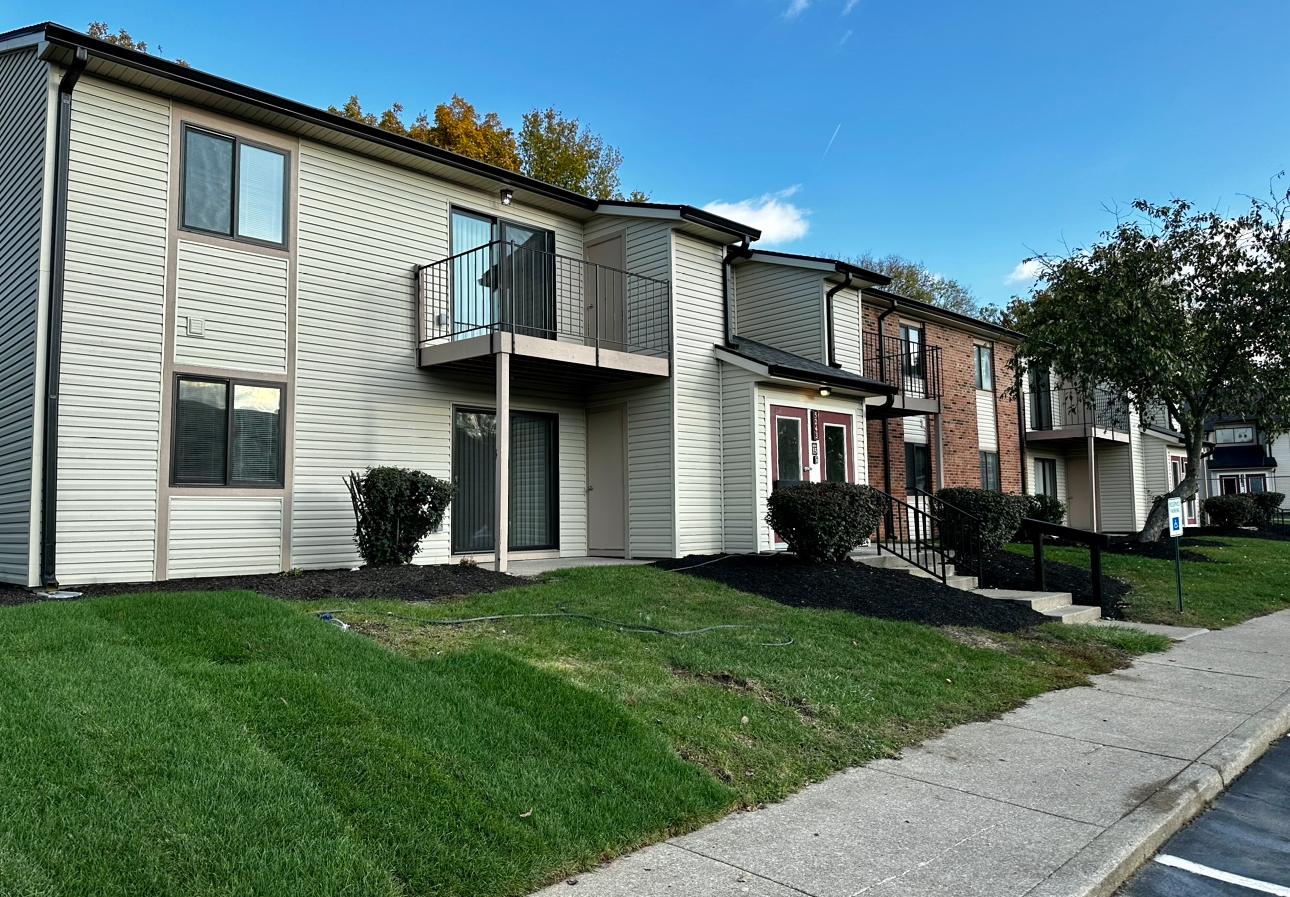 A row of apartment buildings with a sidewalk in front of them