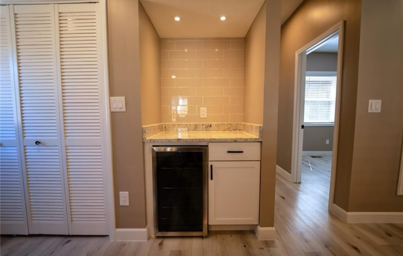 A room with a bar and a refrigerator in it