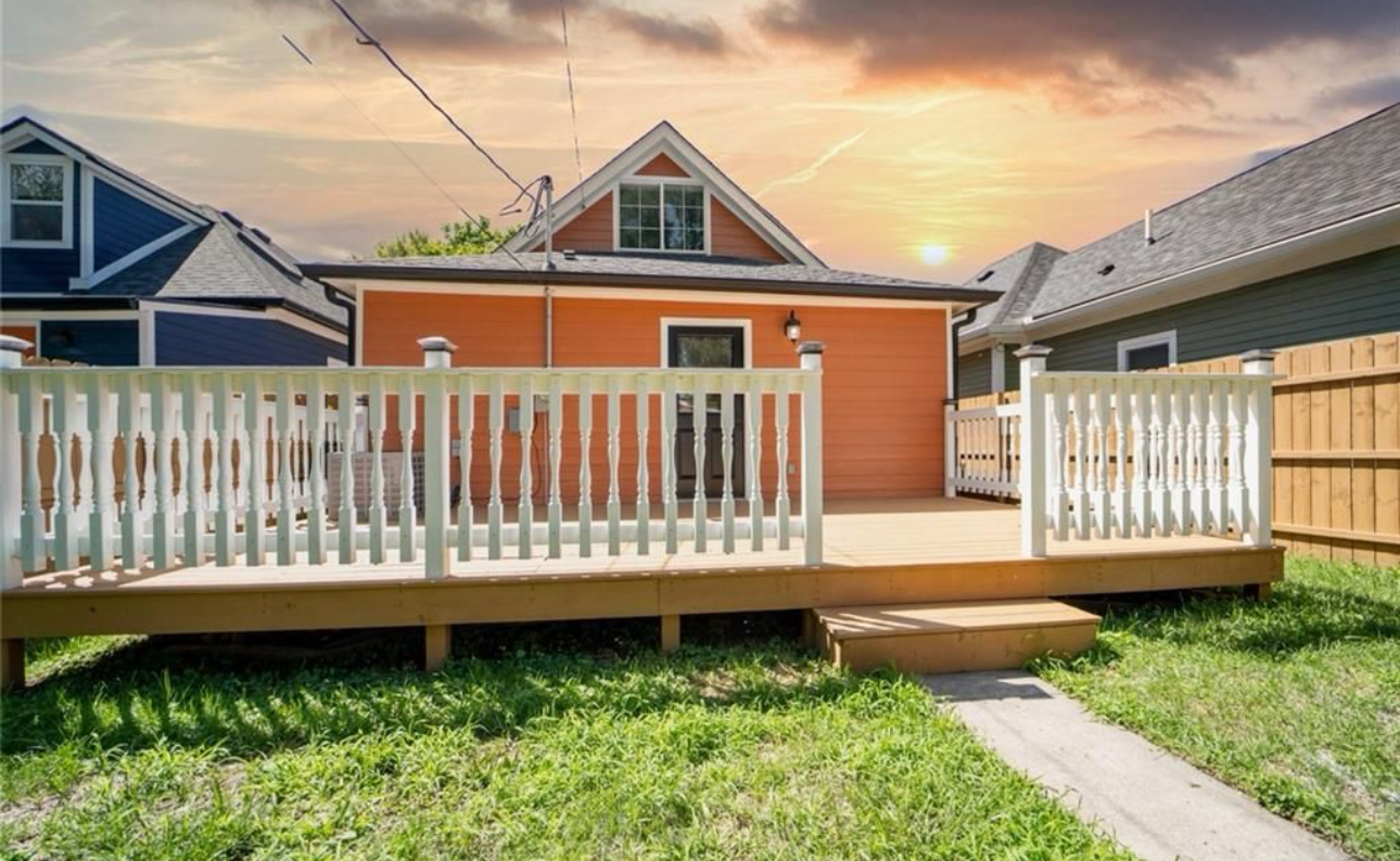 The backyard of a house with a deck and fence