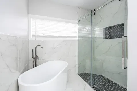 A bathroom with a bathtub and a walk in shower.