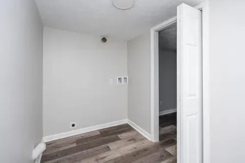 An empty room with hardwood floors and white walls.