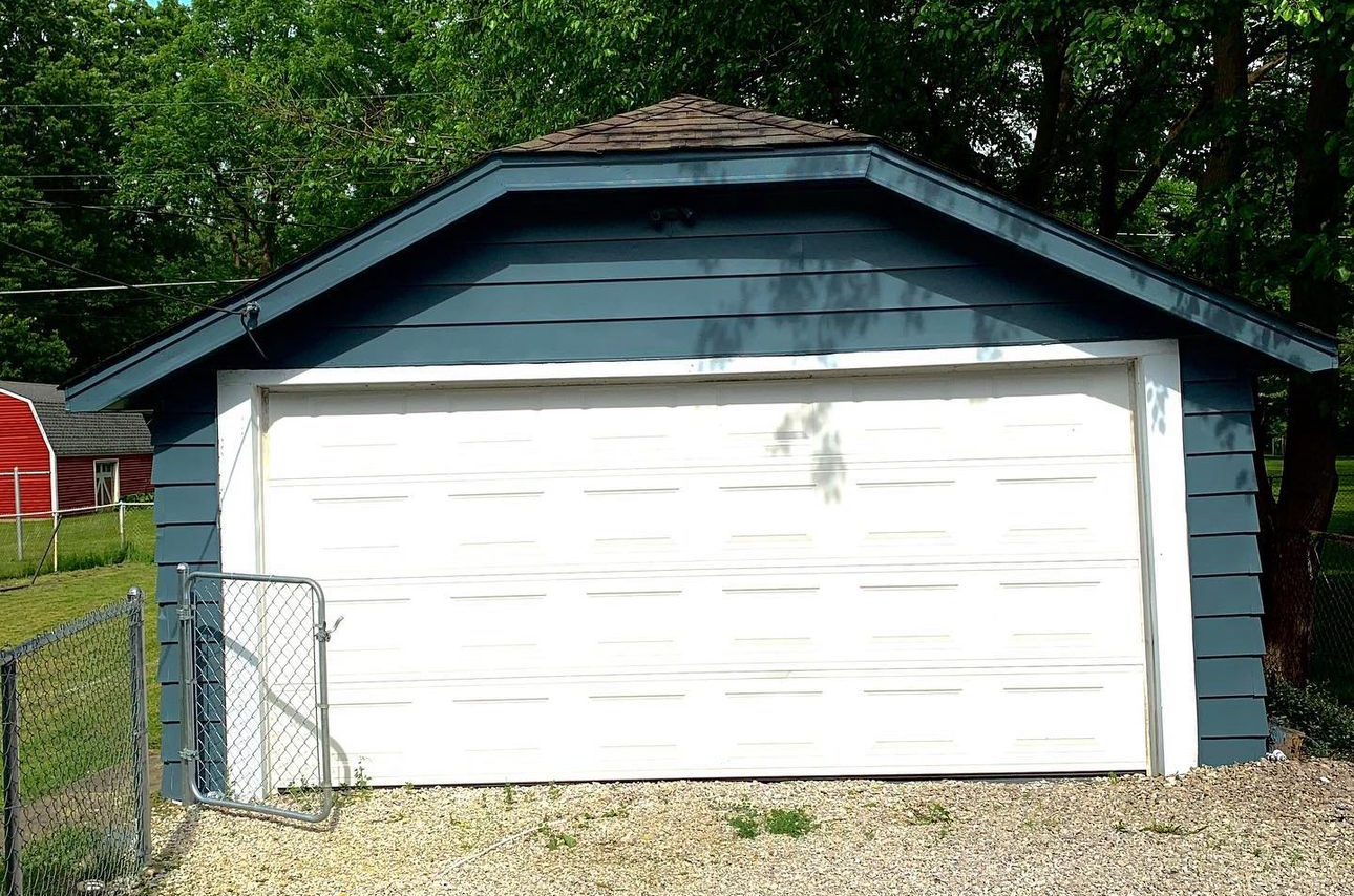 A blue and white garage with a white garage door.