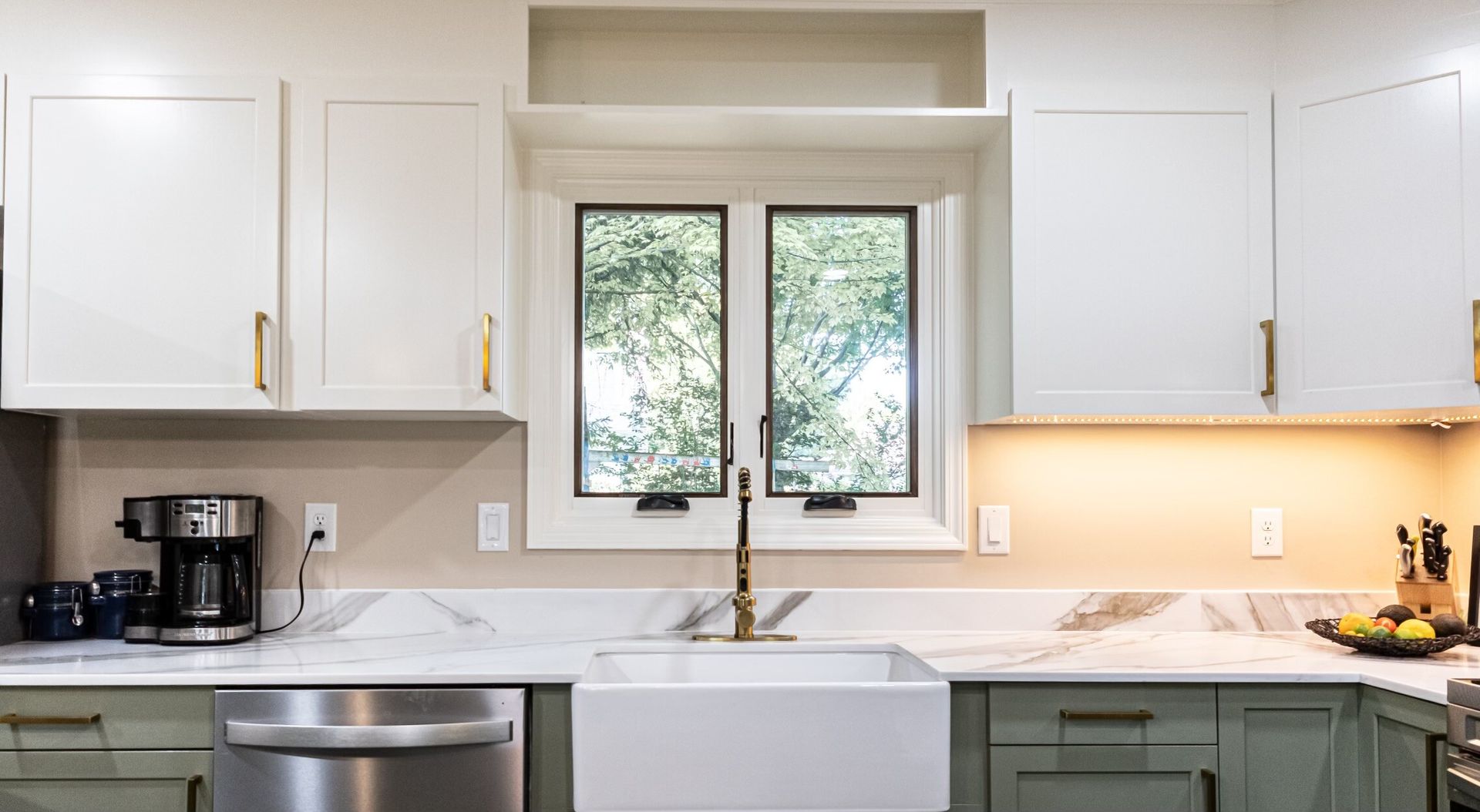 remodeled marble kitchen counters with farmhouse sink and gold handle trim