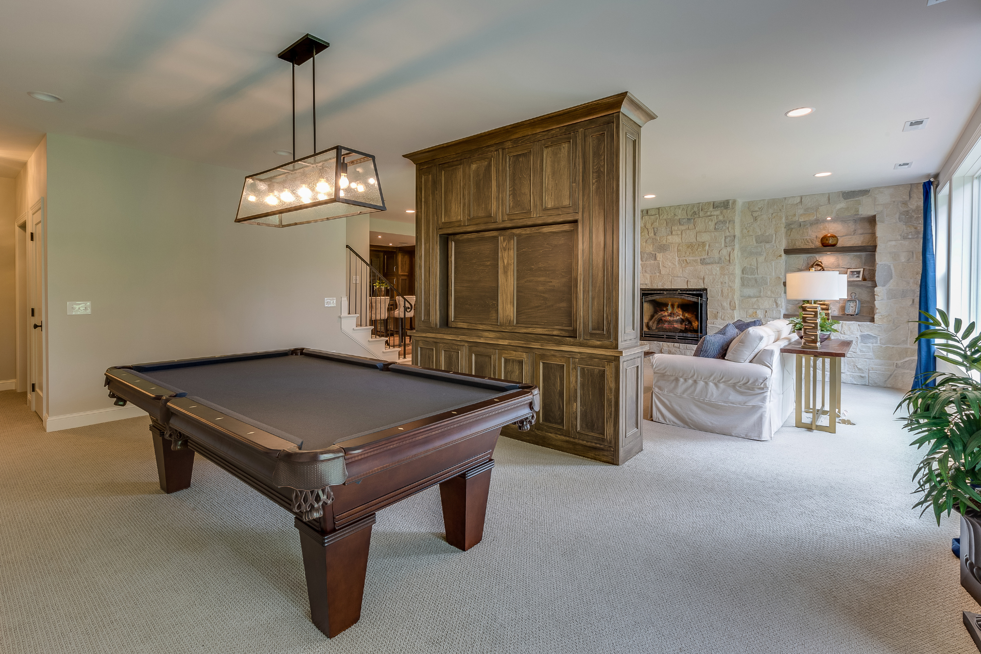 A pool table in a living room next to a fireplace.