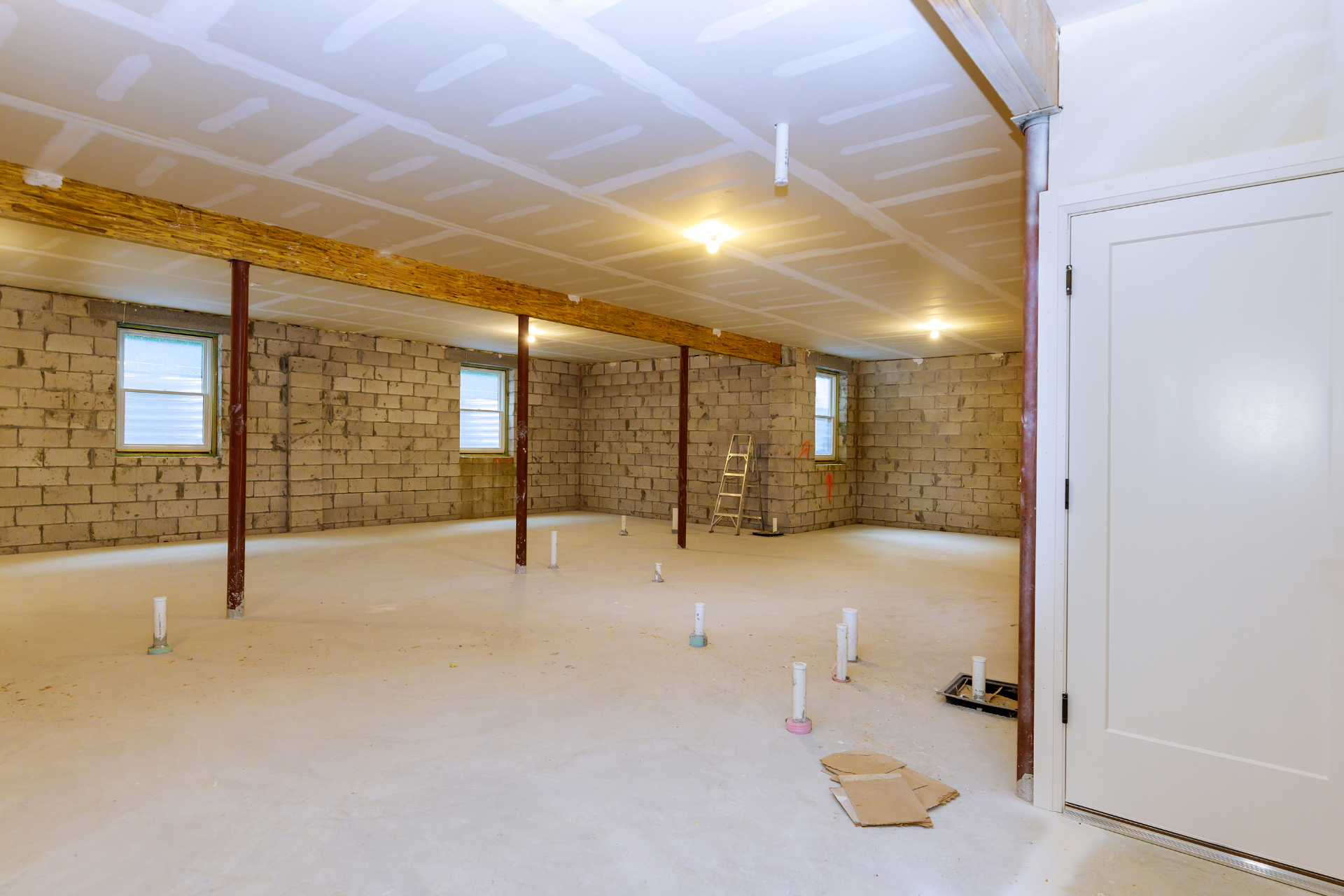 An empty basement with brick walls and a white carpet.