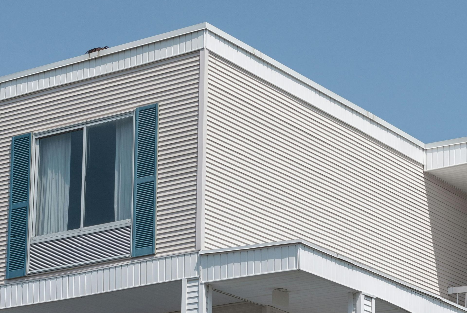A patio with a table and chairs and an umbrella in front of a house