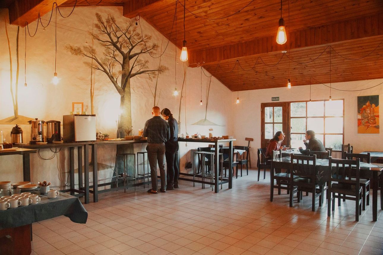 Un grupo de personas están sentadas en las mesas de un restaurante.