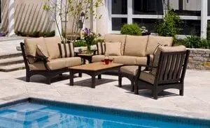 A patio set is sitting next to a swimming pool.