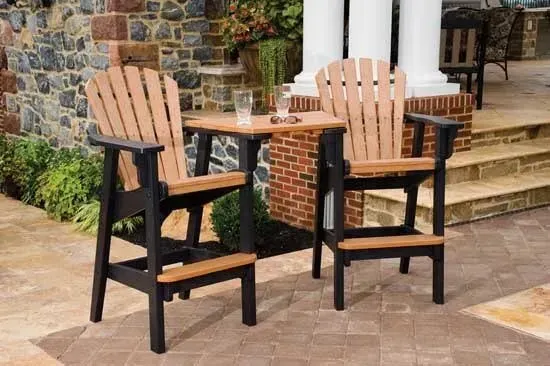 Two chairs and a table on a patio in front of a brick building.