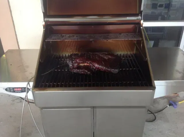 A large piece of meat is cooking on a grill