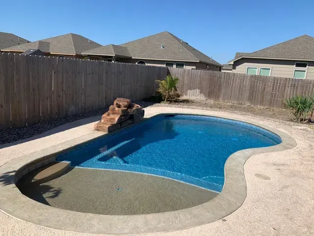 A large swimming pool in the backyard of a house