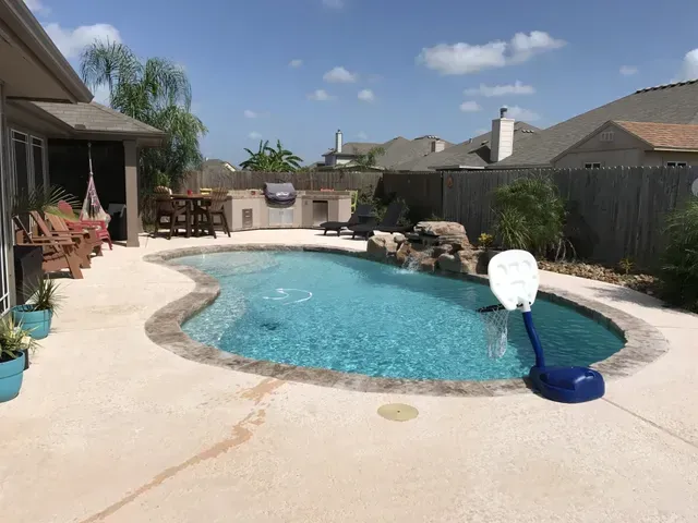 A large swimming pool with a basketball hoop in the middle of it