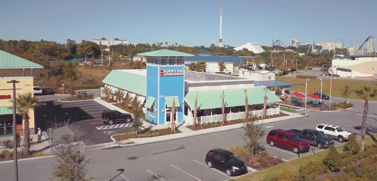 An aerial view of a parking lot with a blue building in the background