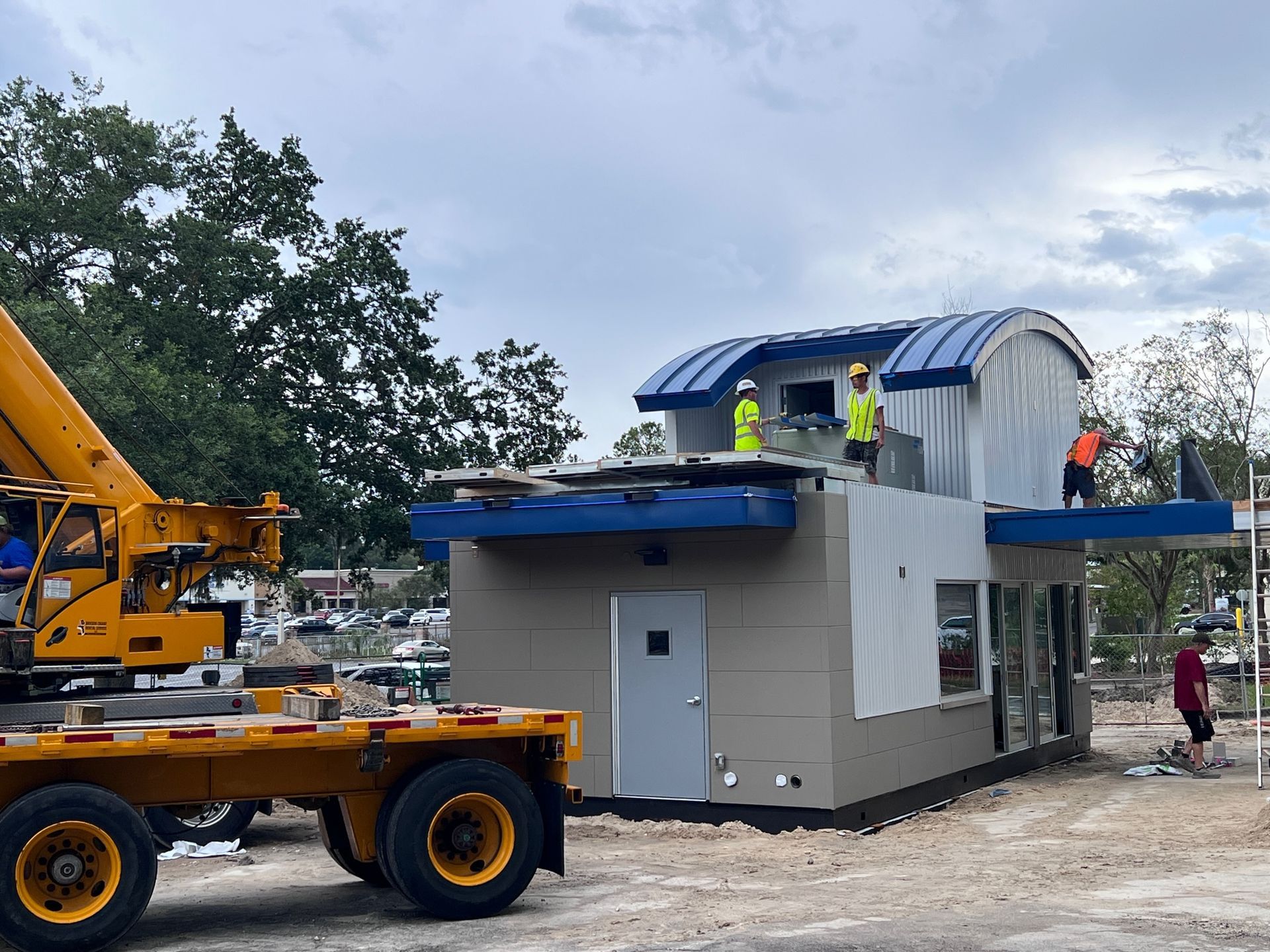 A yellow truck is being towed by a crane