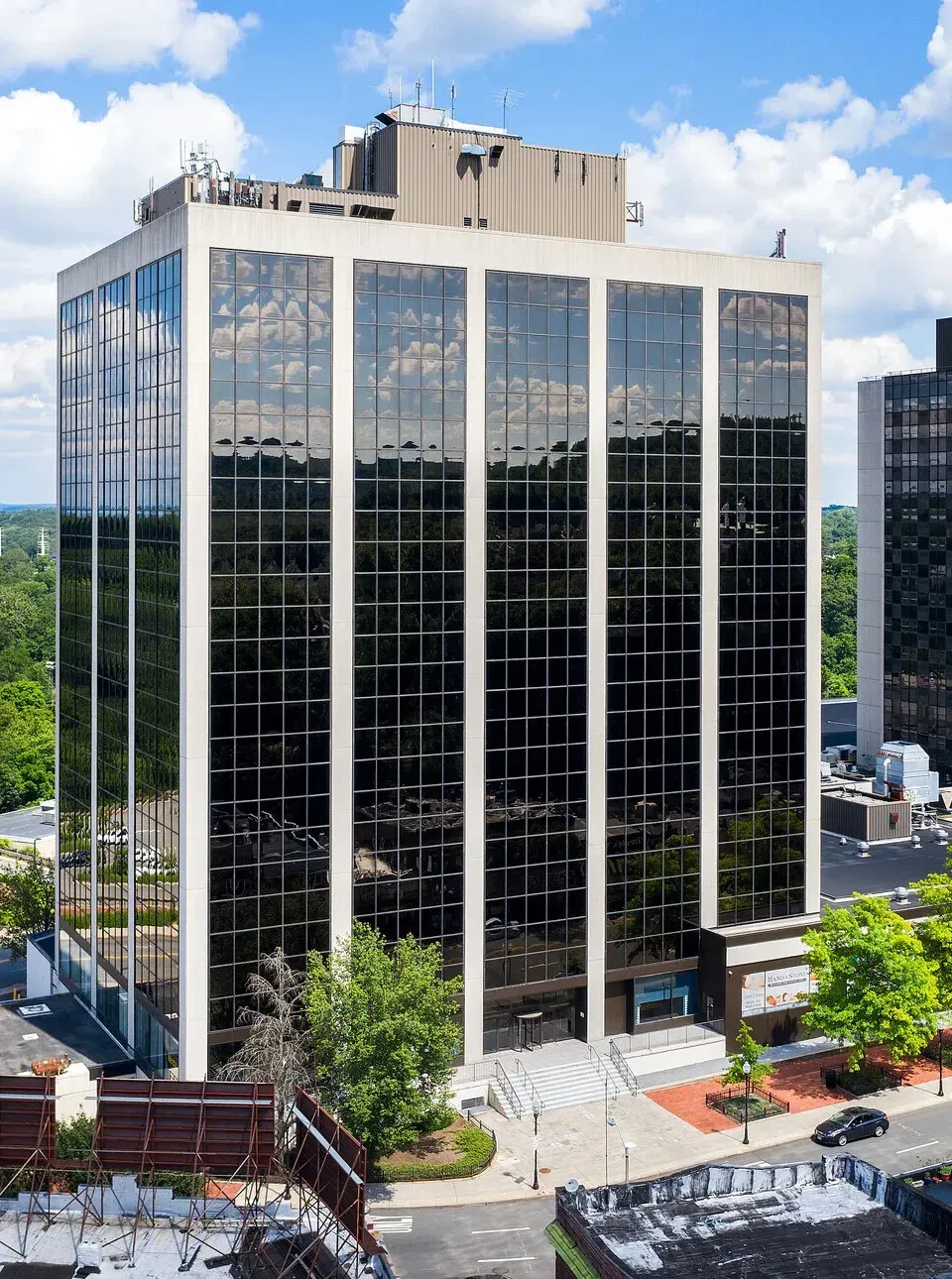 An aerial view of a tall building with lots of windows in a city.