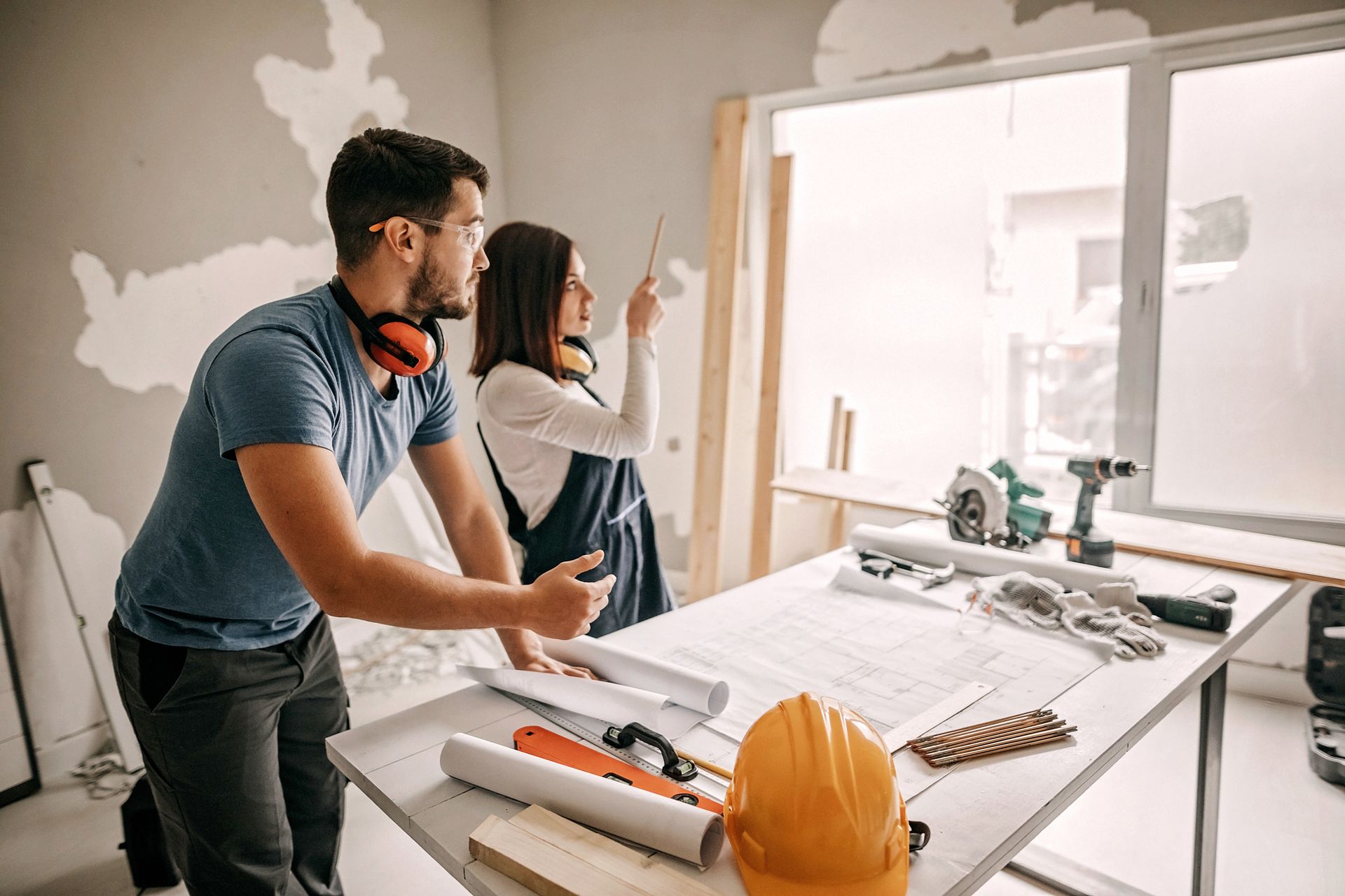 A man and a woman are standing next to a table in a room — Clifton, NJ — New Alp Construction