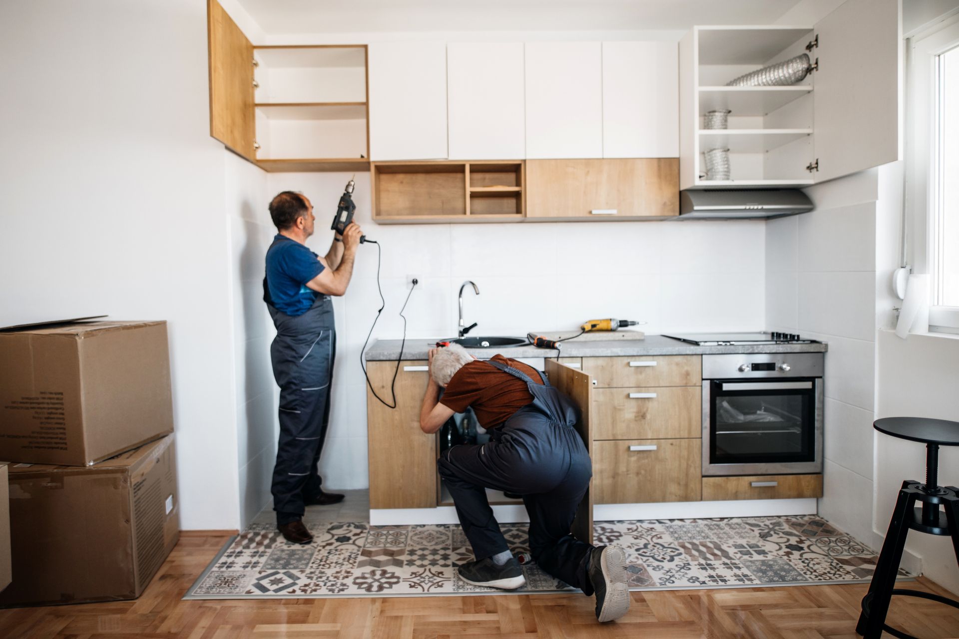 Two men are installing cabinets in a kitchen — Clifton, NJ — New Alp Construction