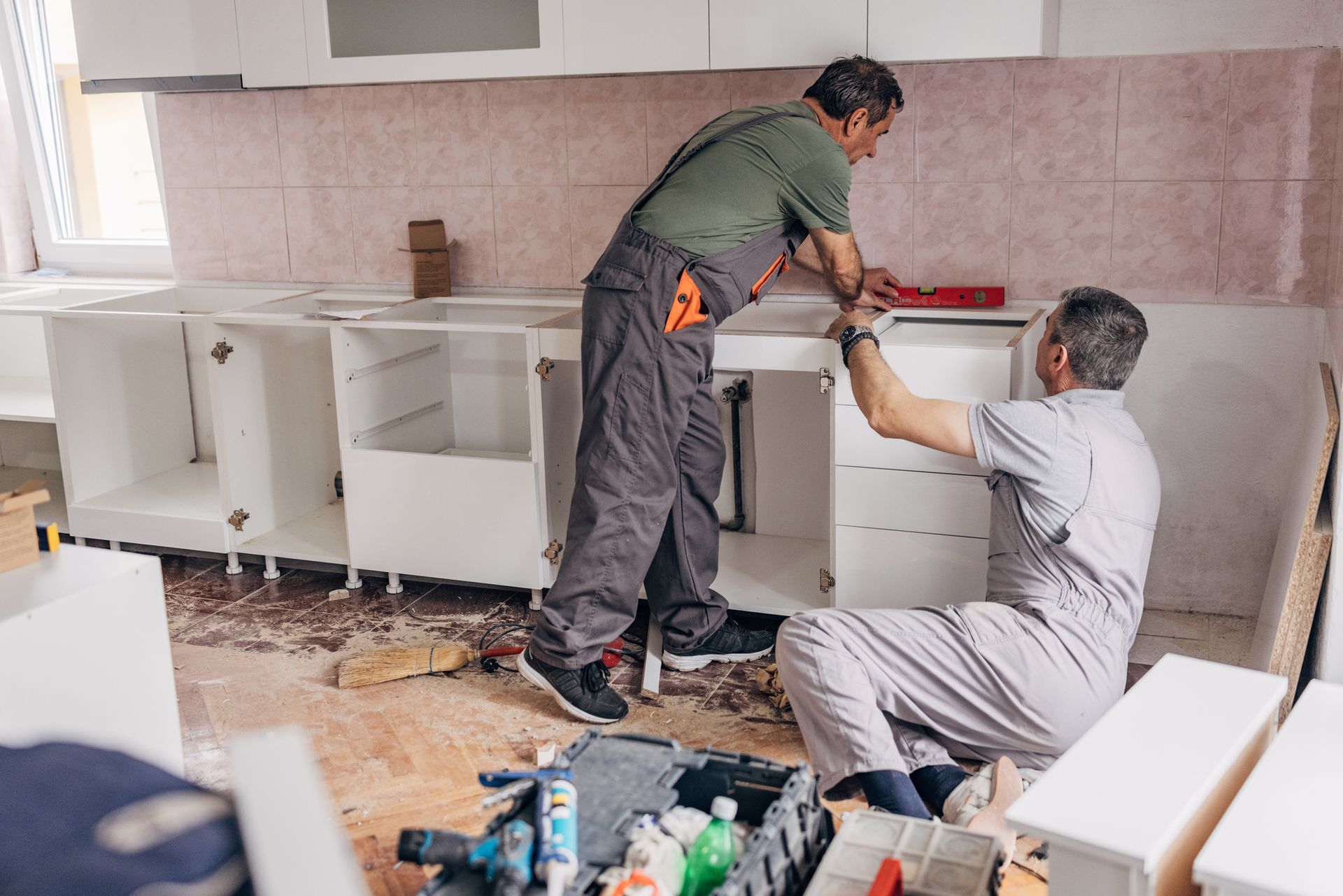 Two men are installing cabinets in a kitchen — Clifton, NJ — New Alp Construction