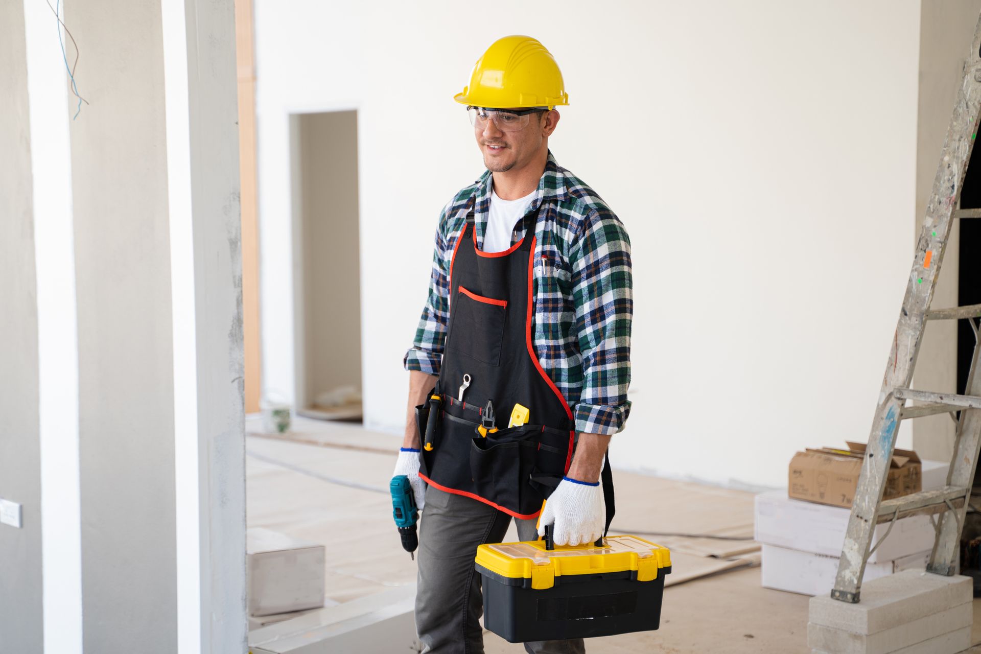 A construction worker is carrying a toolbox in a building under construction — Clifton, NJ — New Alp Construction