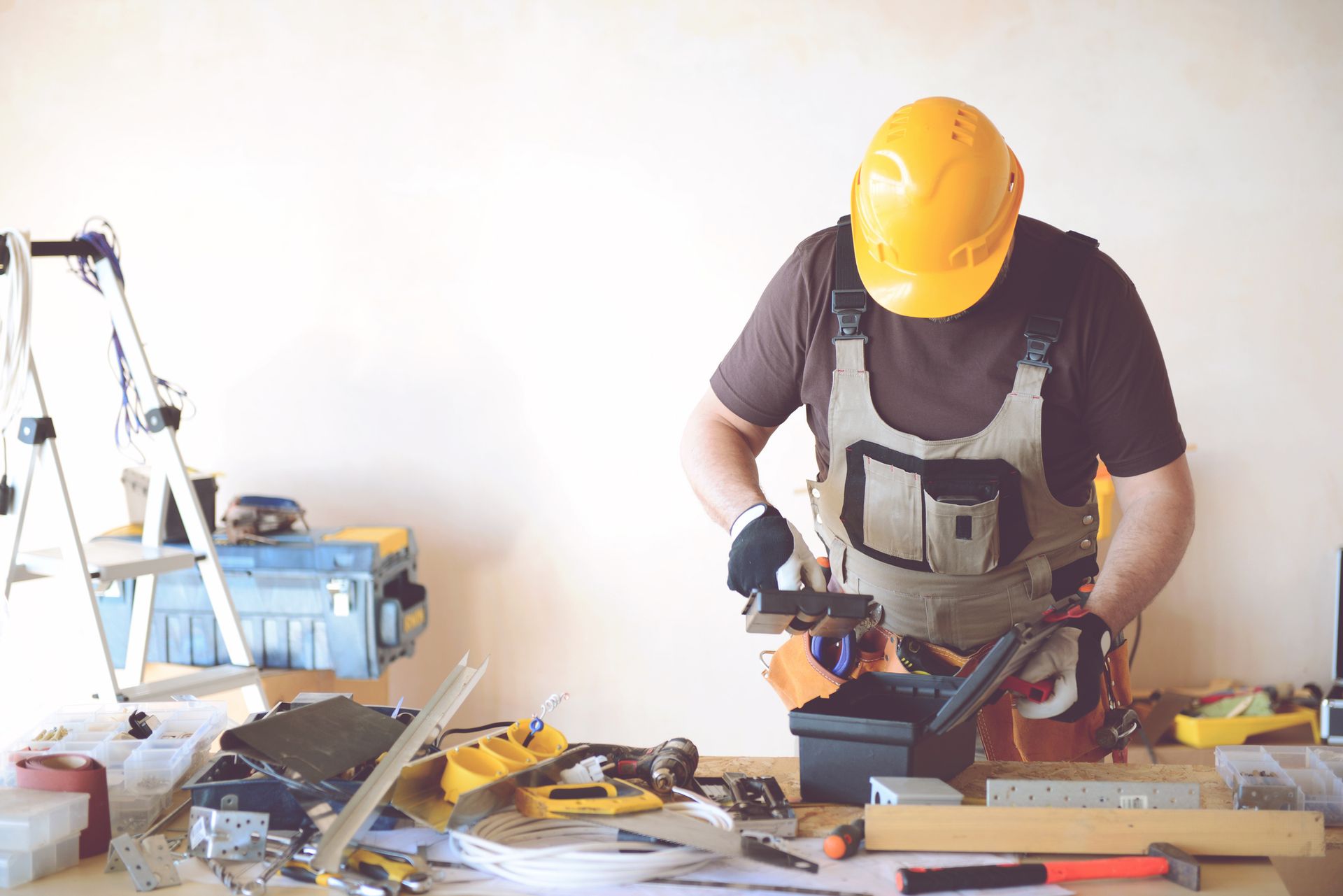 A man wearing a hard hat is working on a table with tools — Clifton, NJ — New Alp Construction