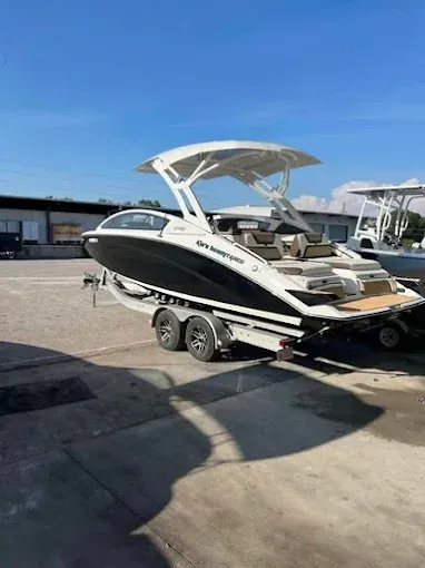 Black and white motorboat on a trailer against a blue sky.