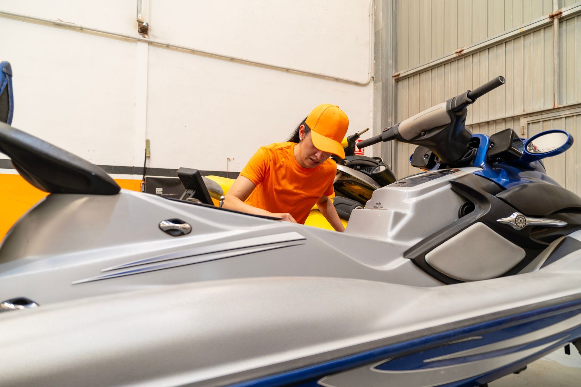 Mechanic working on a watercraft at a boat repair shop, ensuring expert maintenance.