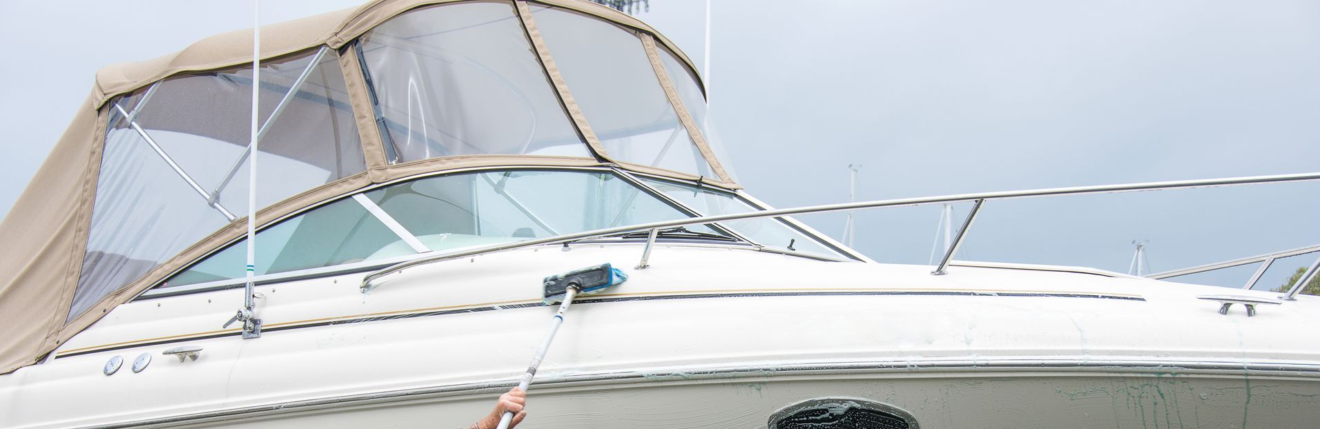 A row of green and white jet skis are parked in a parking lot.